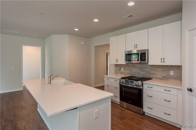 5142 Stavely Rd, Chester, VA 23831 - kitchen featuring appliances with stainless steel finishes, a sink, a center island with sink, dark wood-style floors, and tasteful backsplash