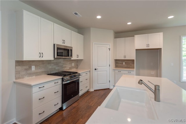 5142 Stavely Rd, Chester, VA 23831 - kitchen featuring appliances with stainless steel finishes, a sink, dark wood finished floors, white cabinets, and recessed lighting