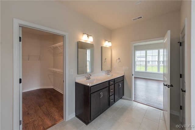 5142 Stavely Rd, Chester, VA 23831 - bathroom featuring double vanity, baseboards, a spacious closet, and wood finished floors