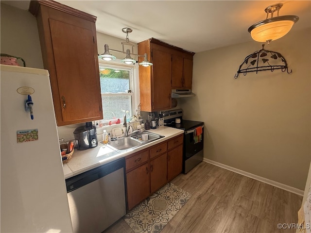 13107 Five Forks Rd, Amelia Courthouse, VA 23002 - kitchen with stainless steel appliances, under cabinet range hood, light countertops, a sink, and light wood finished floors