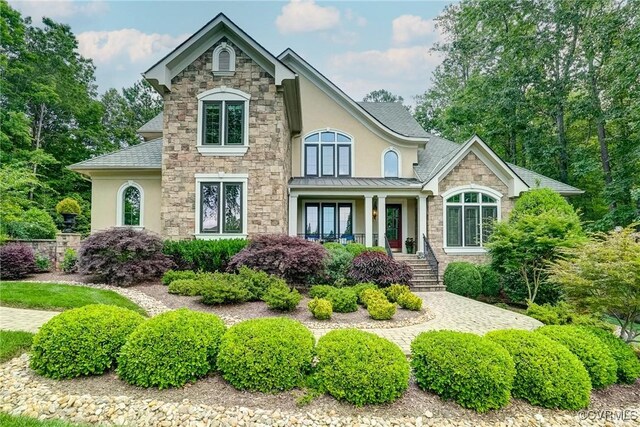 717 Old Stream Rd, Manakin Sabot, VA 23103 - view of front facade featuring stone siding, covered porch, a standing seam roof, stucco siding, and a shingled roof
