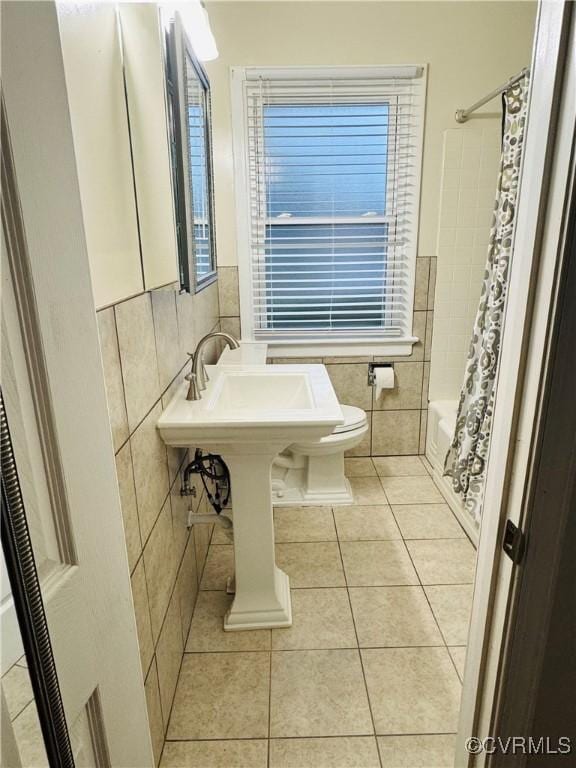 2708 Elgin Rd, Henrico, VA 23223 - full bath featuring tile walls, tile patterned floors, shower / bathtub combination with curtain, toilet, and wainscoting