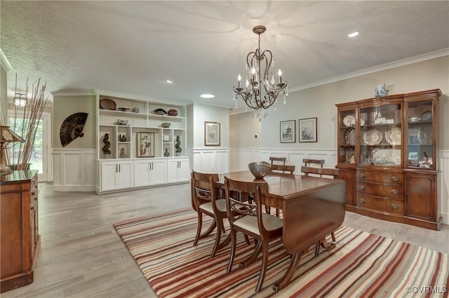 1825 Rock Point Dr, Powhatan, VA 23139 - dining room featuring a chandelier, a wainscoted wall, a decorative wall, ornamental molding, and light wood-style floors