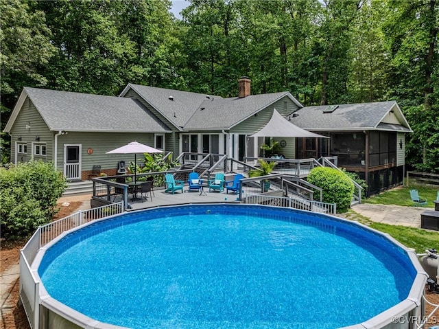 1825 Rock Point Dr, Powhatan, VA 23139 - swimming pool featuring a sunroom, a wooden deck, outdoor dining space, and a patio