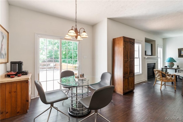 8401 Bethia Rd, Chesterfield, VA 23832 - dining area featuring dark wood-style flooring, plenty of natural light, a chandelier, a glass covered fireplace, and a textured ceiling