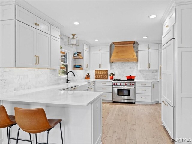 200 N Ridge Rd, Henrico, VA 23229 - kitchen with premium range hood, high quality appliances, a sink, a peninsula, and white cabinets