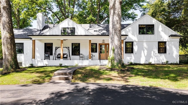 200 N Ridge Rd, Henrico, VA 23229 - modern farmhouse featuring board and batten siding, brick siding, a porch, a front lawn, and a chimney