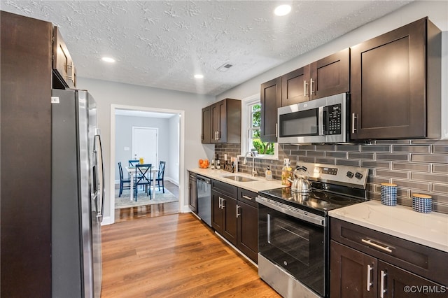 2039 Richmond Ave, Petersburg, VA 23803 - kitchen with stainless steel appliances, a sink, light wood-type flooring, dark brown cabinetry, and recessed lighting