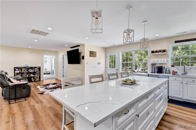 8118 Mimosa Hill Ln, Mechanicsville, VA 23116 - kitchen with light wood-type flooring, white cabinets, recessed lighting, healthy amount of natural light, and light stone countertops