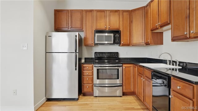 1901 E Broad St Unit U31, Richmond, VA 23223 - kitchen featuring appliances with stainless steel finishes, a sink, dark countertops, and light wood-type flooring