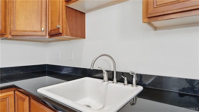 1901 E Broad St Unit U31, Richmond, VA 23223 - kitchen view of a sink, dark countertops, and brown cabinetry