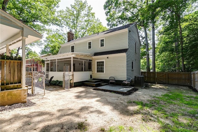 501 Eastman Rd, Chesterfield, VA 23236 - back of property with a sunroom, a chimney, a gate, central AC, and a fenced backyard