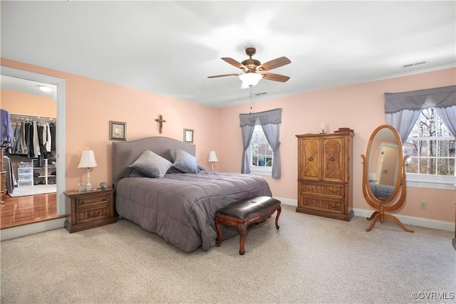10003 Four Iron Ct, Fredericksburg, VA 22408 - carpeted bedroom featuring multiple windows, a spacious closet, a ceiling fan, and a closet