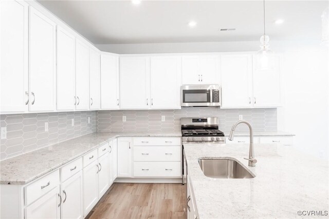 18709 Palisades Cove Trl, Moseley, VA 23120 - kitchen featuring stainless steel microwave, white cabinets, backsplash, hanging light fixtures, and recessed lighting