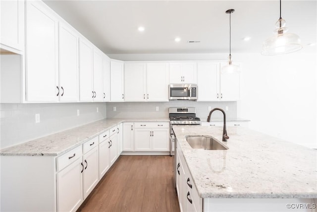 18713 Palisades Cove Trl, Moseley, VA 23120 - kitchen featuring stainless steel microwave, a center island with sink, white cabinets, wood finished floors, and recessed lighting