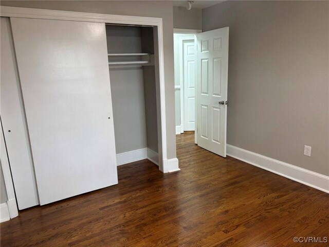 23766 Kings Hwy, Warsaw, VA 22572 - unfurnished bedroom featuring a closet, dark wood finished floors, and baseboards