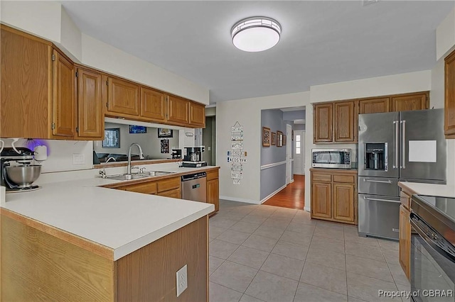 802 Westgate Ct, Newport News, VA 23602 - kitchen featuring appliances with stainless steel finishes, a sink, light countertops, light tile patterned floors, and brown cabinetry
