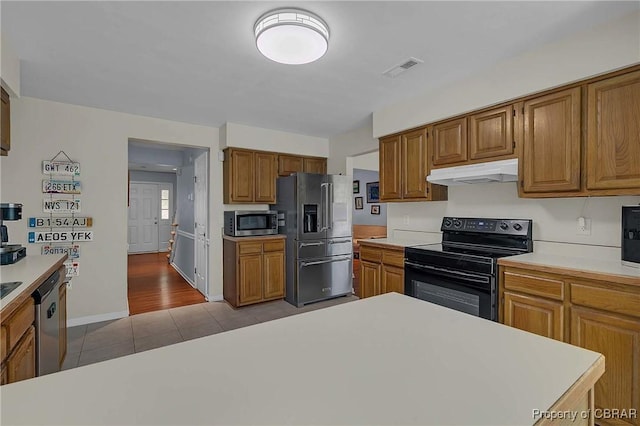 802 Westgate Ct, Newport News, VA 23602 - kitchen with appliances with stainless steel finishes, under cabinet range hood, light countertops, tile patterned flooring, and brown cabinets