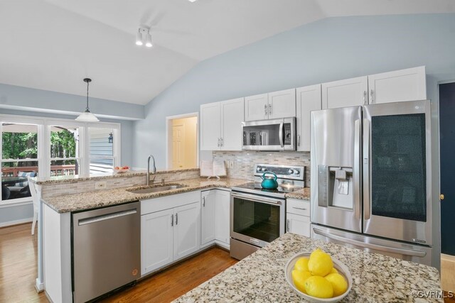 15300 Houndmaster Cir, Midlothian, VA 23112 - kitchen with stainless steel appliances, a sink, vaulted ceiling, wood finished floors, and a peninsula