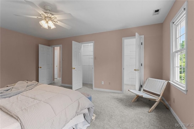 6730 Bryanbell Dr, North Chesterfield, VA 23234 - bedroom with baseboards, light carpet, a walk in closet, connected bathroom, and a ceiling fan