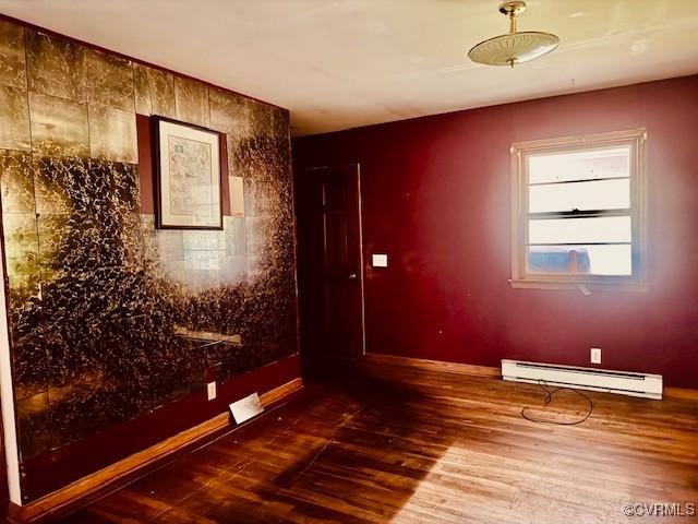 25468 Woodland Park Cir, Courtland, VA 23837 - spare room with a baseboard radiator, dark wood-type flooring, and baseboards