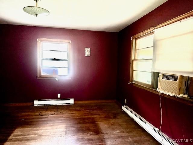 25468 Woodland Park Cir, Courtland, VA 23837 - empty room with a baseboard heating unit, wood finished floors, baseboards, and cooling unit