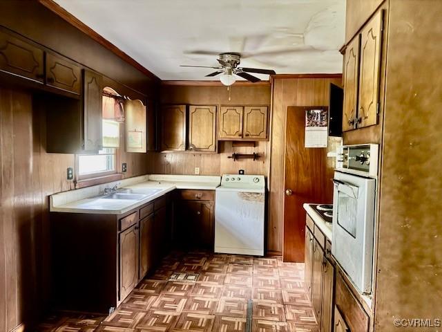 25468 Woodland Park Cir, Courtland, VA 23837 - kitchen with washer / clothes dryer, white oven, a ceiling fan, wood walls, and light countertops