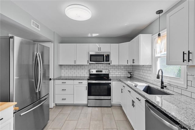 1409 Sycamore Ridge Ct, Midlothian, VA 23114 - kitchen with appliances with stainless steel finishes, a sink, white cabinetry, light stone counters, and decorative backsplash