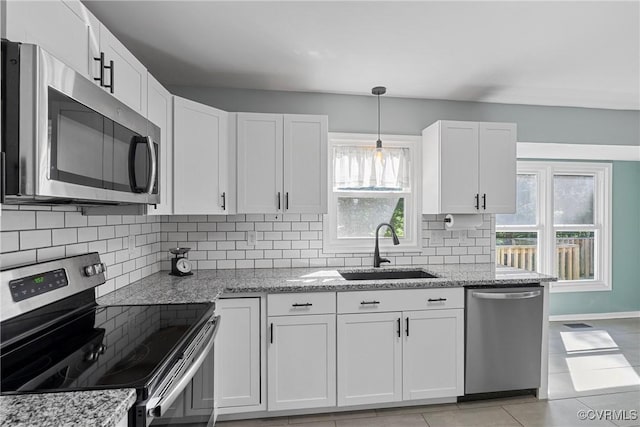 1409 Sycamore Ridge Ct, Midlothian, VA 23114 - kitchen with stainless steel appliances, a sink, decorative backsplash, white cabinetry, and light stone countertops