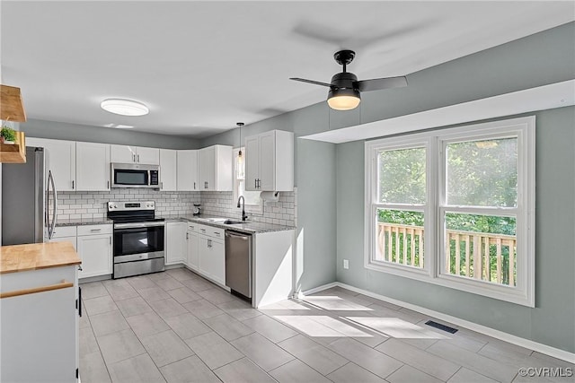 1409 Sycamore Ridge Ct, Midlothian, VA 23114 - kitchen with stainless steel appliances, a sink, wood counters, decorative backsplash, and white cabinetry