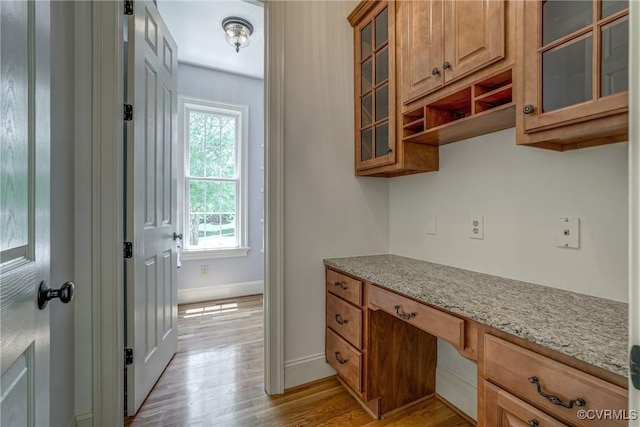 3330 Handley Rd, Midlothian, VA 23113 - kitchen featuring light wood-style floors, baseboards, brown cabinetry, light stone countertops, and glass insert cabinets