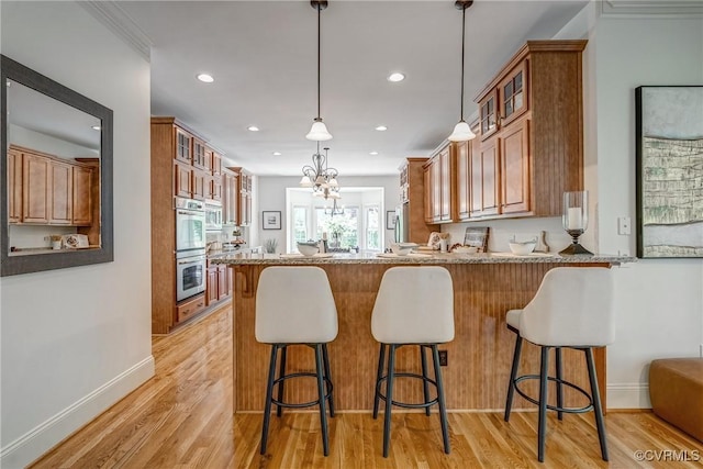 3330 Handley Rd, Midlothian, VA 23113 - kitchen with brown cabinets, glass insert cabinets, a peninsula, double oven, and light wood-type flooring