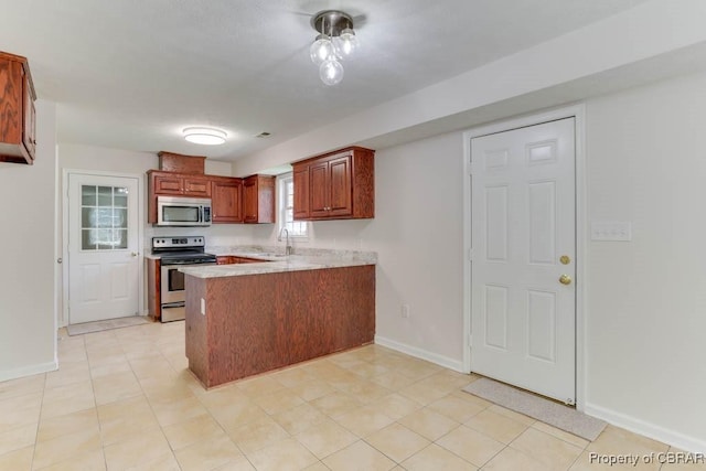 1928 Box St, Hampton, VA 23661 - kitchen with appliances with stainless steel finishes, a peninsula, a sink, baseboards, and light countertops