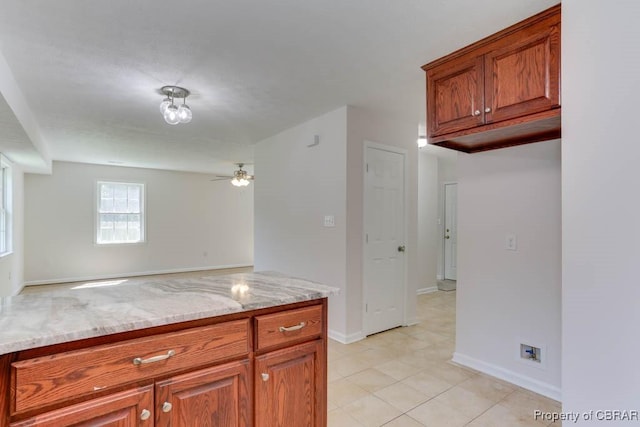 1928 Box St, Hampton, VA 23661 - kitchen featuring ceiling fan, light stone countertops, baseboards, and brown cabinets