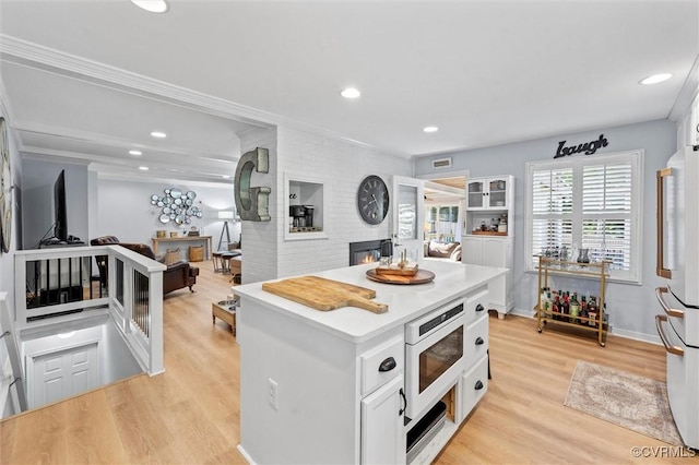 905 Manakin Rd, Midlothian, VA 23113 - kitchen with built in microwave, freestanding refrigerator, white cabinets, a center island, and recessed lighting