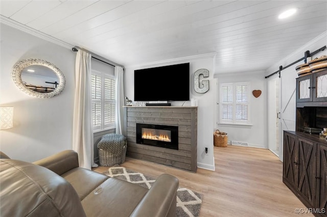 905 Manakin Rd, Midlothian, VA 23113 - living area with a barn door, ornamental molding, a glass covered fireplace, light wood-style flooring, and plenty of natural light