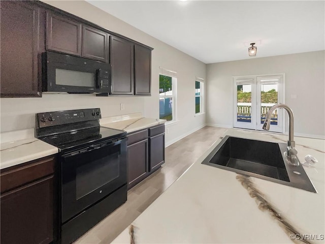 5812 Olas Ct, Richmond, VA 23224 - kitchen featuring black appliances, a sink, light countertops, and plenty of natural light