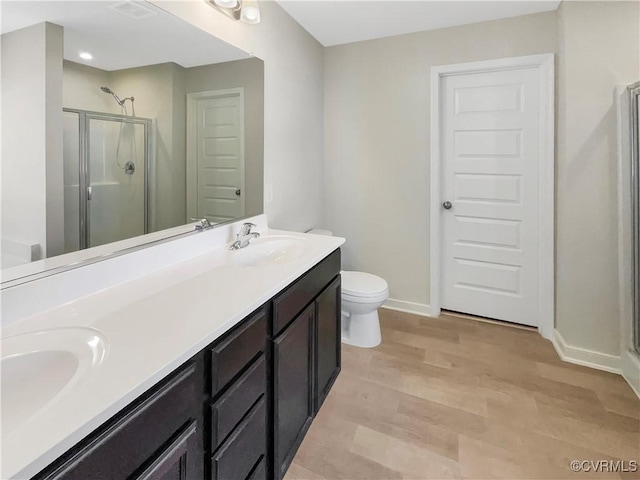5812 Olas Ct, Richmond, VA 23224 - bathroom featuring a shower stall, double vanity, wood finished floors, baseboards, and toilet