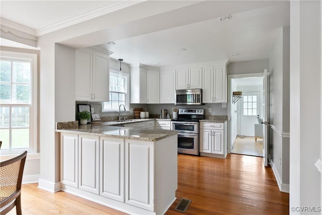 7625 Marilea Rd, Richmond, VA 23225 - kitchen featuring stainless steel appliances, light wood-style flooring, a peninsula, white cabinetry, and recessed lighting