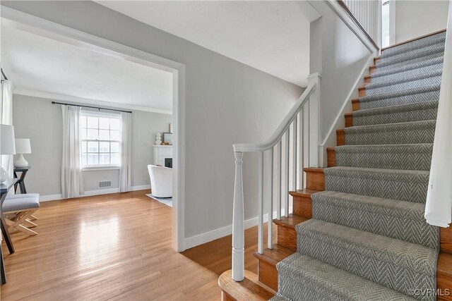 7625 Marilea Rd, Richmond, VA 23225 - stairway featuring wood finished floors, baseboards, crown molding, and a fireplace