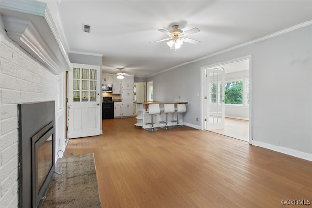 11440 Bienvenue Rd, Rockville, VA 23146 - unfurnished living room featuring a fireplace, a ceiling fan, ornamental molding, wood finished floors, and baseboards