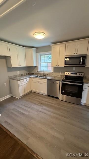 9014 Weldon Dr, Henrico, VA 23229 - kitchen featuring stainless steel appliances, a sink, light wood-type flooring, white cabinetry, and baseboards