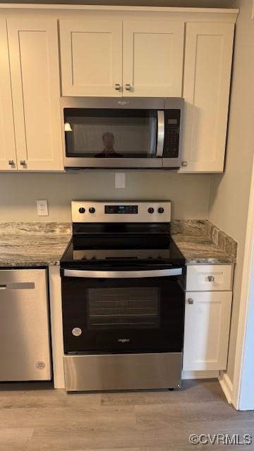 9014 Weldon Dr, Henrico, VA 23229 - kitchen with stainless steel appliances, white cabinets, light wood-style flooring, and light stone countertops