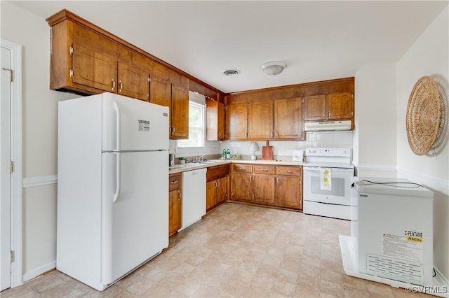 3307 Carlisle Ave, Hopewell, VA 23860 - kitchen featuring white appliances, brown cabinetry, under cabinet range hood, light countertops, and decorative backsplash