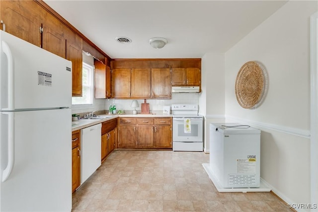 3307 Carlisle Ave, Hopewell, VA 23860 - kitchen with white appliances, a sink, brown cabinets, and under cabinet range hood