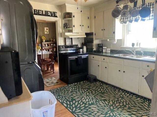 272 Deer Run Trl, Saint Stephens Church, VA 23148 - kitchen featuring black range with electric stovetop, estacked washer and dryer, a sink, under cabinet range hood, and white cabinets