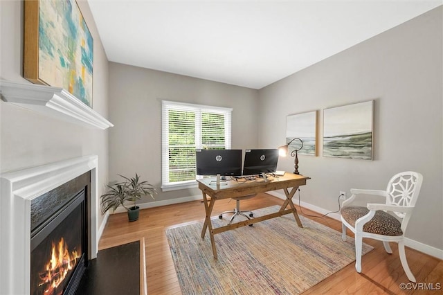 13212 Railey Hill Dr, Midlothian, VA 23114 - home office featuring a warm lit fireplace, baseboards, and wood finished floors