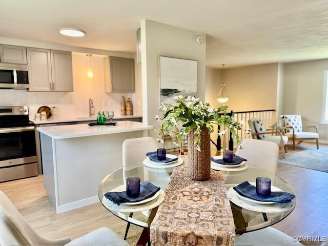 7534 Hollyleaf Ct, Chesterfield, VA 23234 - kitchen with appliances with stainless steel finishes, light countertops, gray cabinets, light wood-type flooring, and a center island