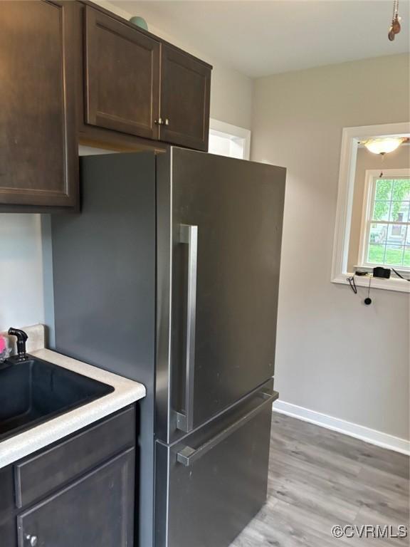 113 N Fern Ave, Highland Springs, VA 23075 - kitchen with a sink, dark brown cabinets, light countertops, baseboards, and light wood-style flooring