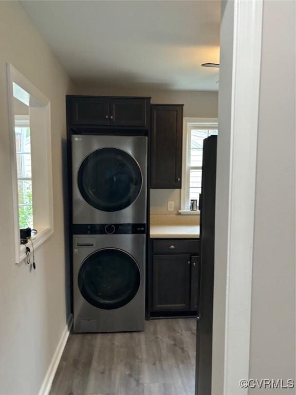 113 N Fern Ave, Highland Springs, VA 23075 - laundry room featuring stacked washer / drying machine, cabinet space, plenty of natural light, and light wood-style flooring